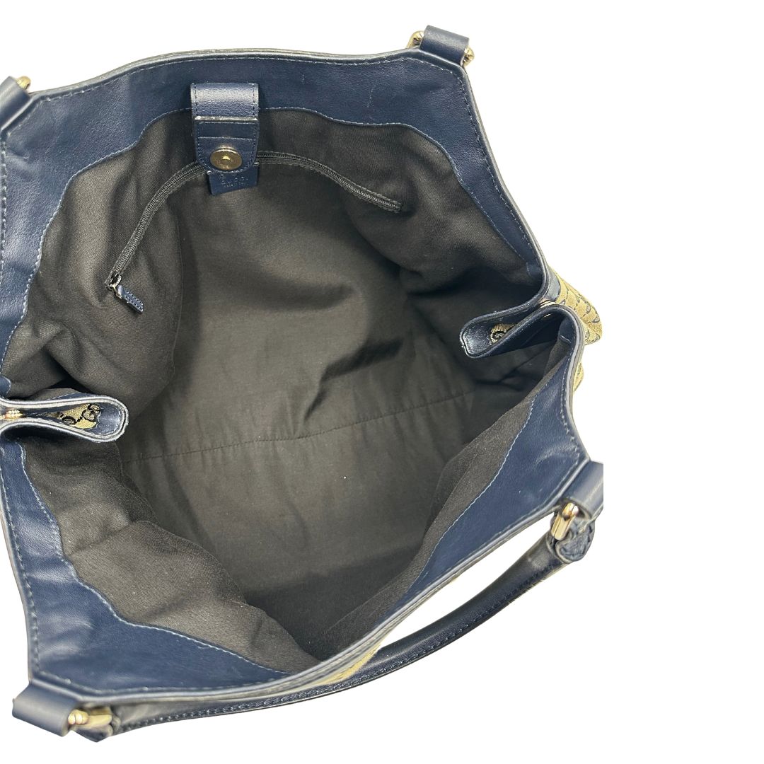 Interno di una Borsa Gucci in tessuto beige GG con parti metalliche dorate e parti in pelle color blu notte; munita di doppi manici stondati. Completa di dustbag. Originale, usata, di lusso, in ottime condizioni.