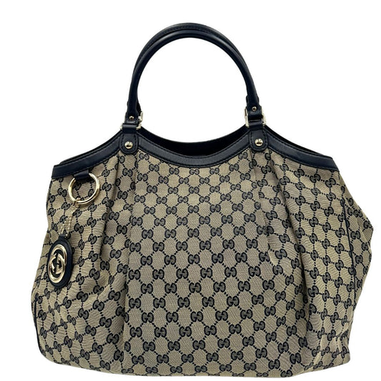 Front di una Borsa Gucci in tessuto beige GG con parti metalliche dorate e parti in pelle color blu notte; munita di doppi manici stondati. Completa di dustbag. Originale, usata, di lusso, in ottime condizioni.