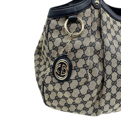 Borsa Gucci in tessuto beige GG con parti metalliche dorate e parti in pelle color blu notte; munita di doppi manici stondati. Completa di dustbag. Originale, usata, di lusso, in ottime condizioni.