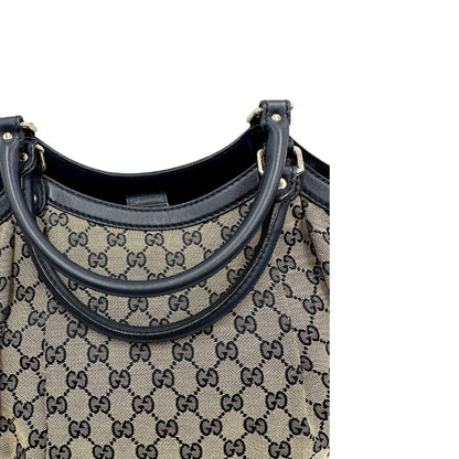 Manici di una Borsa Gucci in tessuto beige GG con parti metalliche dorate e parti in pelle color blu notte; munita di doppi manici stondati. Completa di dustbag. Originale, usata, di lusso, in ottime condizioni.