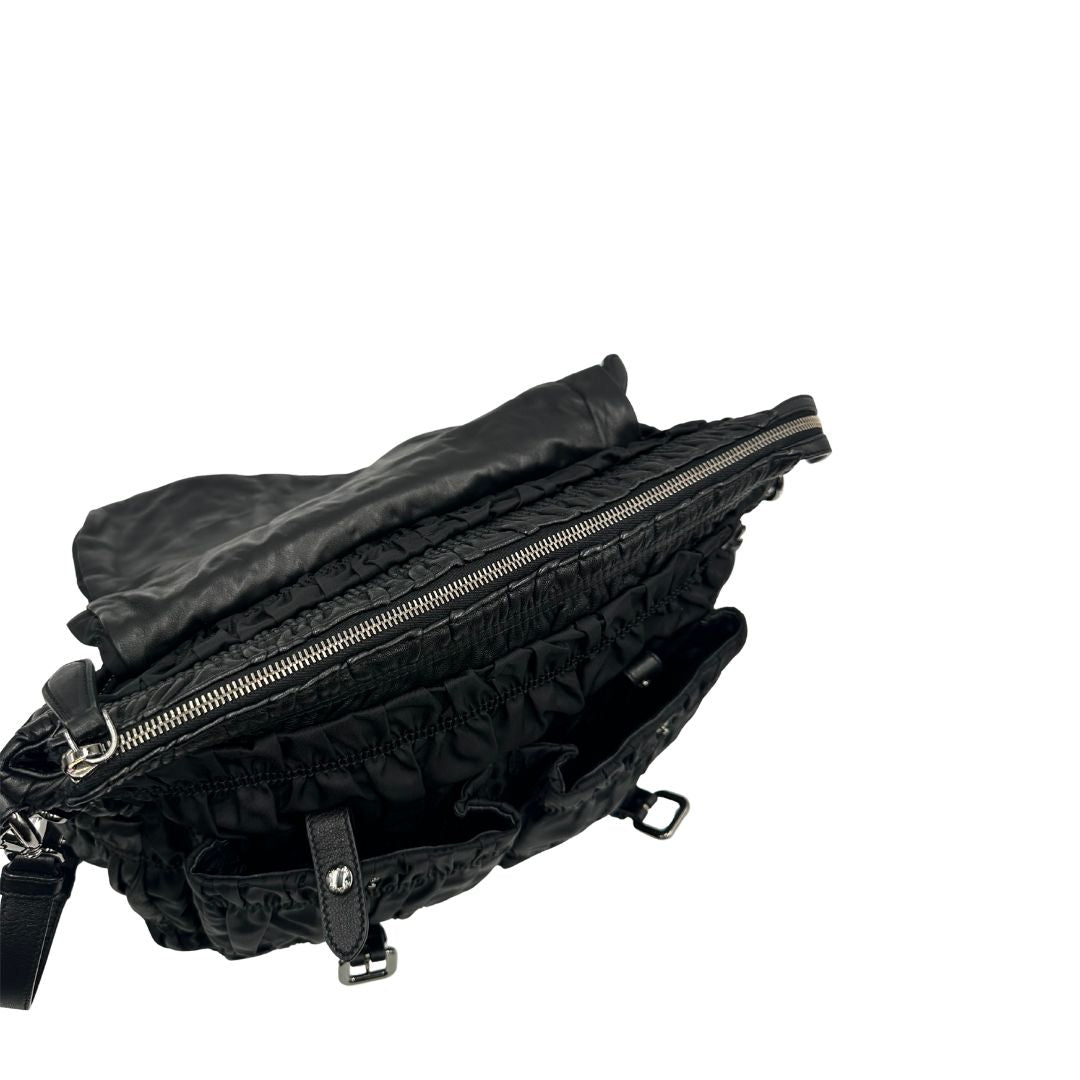 Chiusura di una Borsa Prada in tessuto nylon goffrato nero con parti metalliche argentate e inserti in pelle tono su tono, munita di una tracolla regolabile e amovibile. Completa di dustbag. Originale, usata, di lusso, in ottime condizioni.