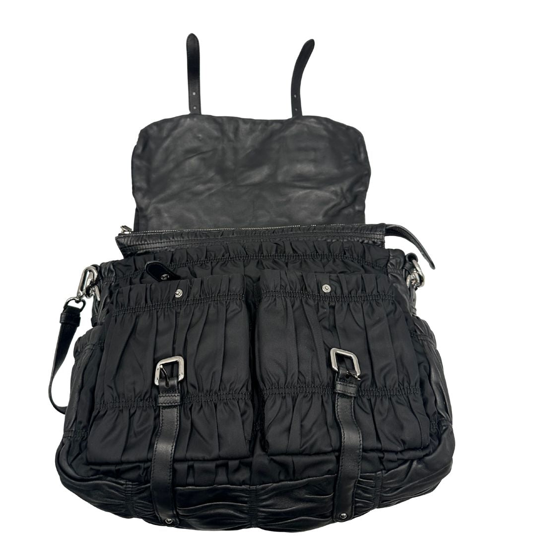 Interno di una Borsa Prada in tessuto nylon goffrato nero con parti metalliche argentate e inserti in pelle tono su tono, munita di una tracolla regolabile e amovibile. Completa di dustbag. Originale, usata, di lusso, in ottime condizioni.