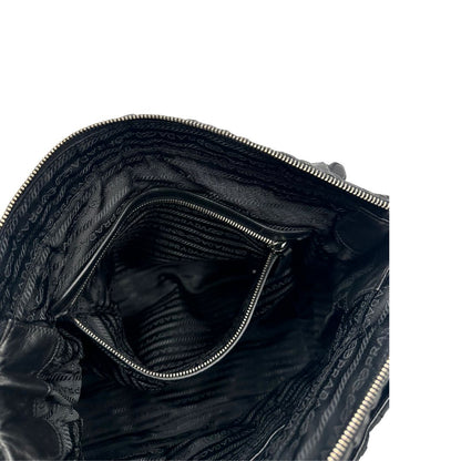 Tasca interna di una Borsa Prada in tessuto nylon goffrato nero con parti metalliche argentate e inserti in pelle tono su tono, munita di una tracolla regolabile e amovibile. Completa di dustbag. Originale, usata, di lusso, in ottime condizioni.