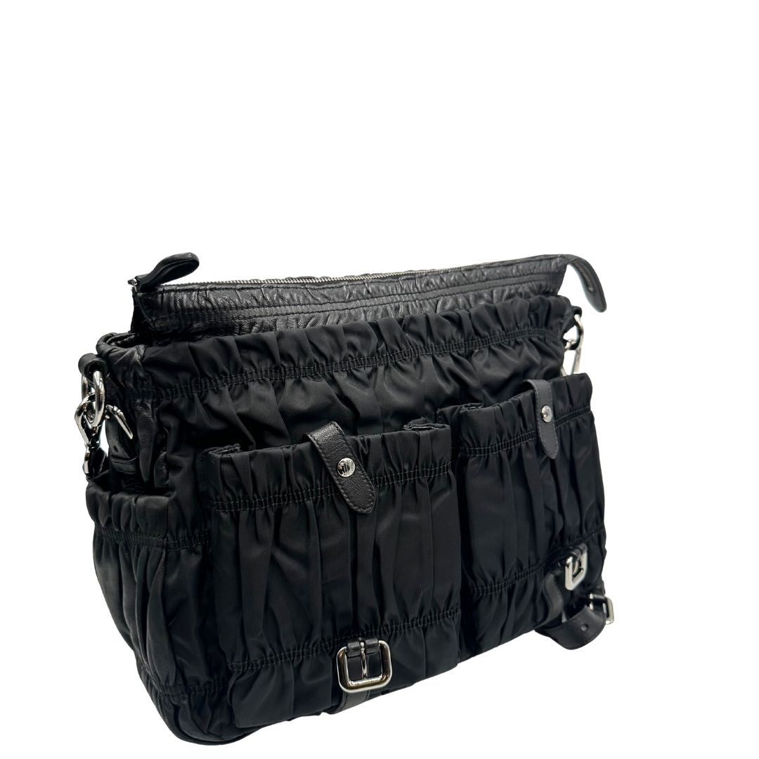 Borsa Prada in tessuto nylon goffrato nero con parti metalliche argentate e inserti in pelle tono su tono, munita di una tracolla regolabile e amovibile. Completa di dustbag. Originale, usata, di lusso, in ottime condizioni.
