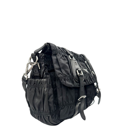 Lato destro di una Borsa Prada in tessuto nylon goffrato nero con parti metalliche argentate e inserti in pelle tono su tono, munita di una tracolla regolabile e amovibile. Completa di dustbag. Originale, usata, di lusso, in ottime condizioni.