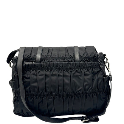 Retro di una Borsa Prada in tessuto nylon goffrato nero con parti metalliche argentate e inserti in pelle tono su tono, munita di una tracolla regolabile e amovibile. Completa di dustbag. Originale, usata, di lusso, in ottime condizioni.