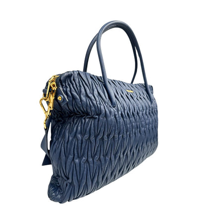 lato  Borsa Miu Miu in pelle matelassè blu con parti metalliche dorate; munita di doppi manici stondati e una tracolla amovibile e regolabile. Completa di dustbag, di lusso, originale, ottime condizioni, usata. 