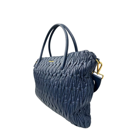 lato Borsa Miu Miu in pelle matelassè blu con parti metalliche dorate; munita di doppi manici stondati e una tracolla amovibile e regolabile. Completa di dustbag, di lusso, originale, ottime condizioni, usata.
