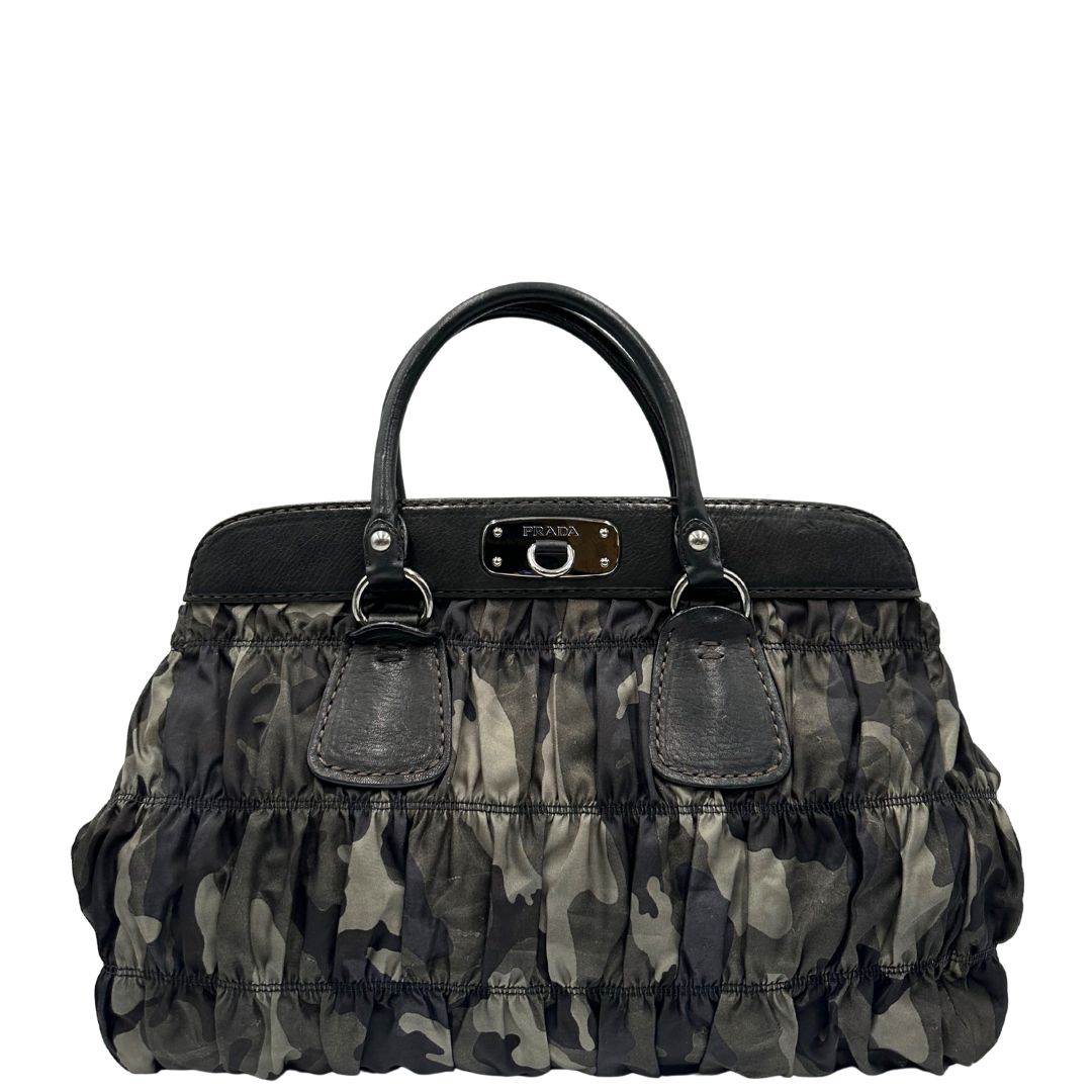 Front di una Borsa Prada in tessuto nylon goffrato trama camouflage nelle tonlità del verde, finiture in pelle nere e inserti metallici argentati; dotata di doppi manici stondati. Completa di dustbag. Originale, usata, di lusso, in ottime condizioni.