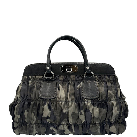 Front di una Borsa Prada in tessuto nylon goffrato trama camouflage nelle tonlità del verde, finiture in pelle nere e inserti metallici argentati; dotata di doppi manici stondati. Completa di dustbag. Originale, usata, di lusso, in ottime condizioni.