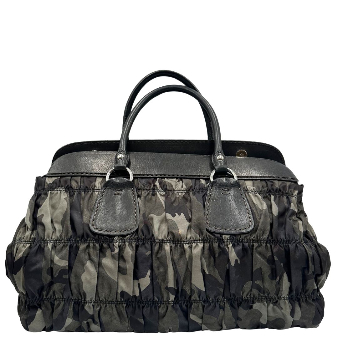 Retro di una Borsa Prada in tessuto nylon goffrato trama camouflage nelle tonlità del verde, finiture in pelle nere e inserti metallici argentati; dotata di doppi manici stondati. Completa di dustbag. Originale, usata, di lusso, in ottime condizioni.