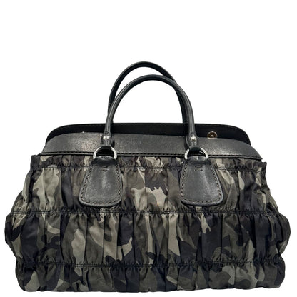 Retro di una Borsa Prada in tessuto nylon goffrato trama camouflage nelle tonlità del verde, finiture in pelle nere e inserti metallici argentati; dotata di doppi manici stondati. Completa di dustbag. Originale, usata, di lusso, in ottime condizioni.