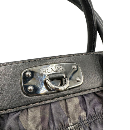 Borsa Prada in tessuto nylon goffrato trama camouflage nelle tonlità del verde, finiture in pelle nere e inserti metallici argentati; dotata di doppi manici stondati. Completa di dustbag. Originale, usata, di lusso, in ottime condizioni.