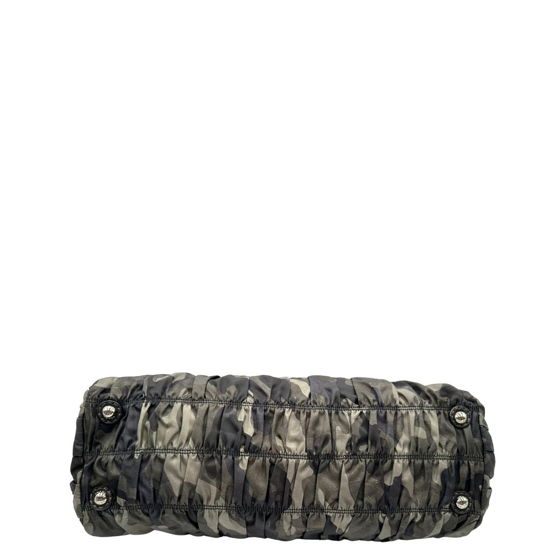 Base di una Borsa Prada in tessuto nylon goffrato trama camouflage nelle tonlità del verde, finiture in pelle nere e inserti metallici argentati; dotata di doppi manici stondati. Completa di dustbag. Originale, usata, di lusso, in ottime condizioni.