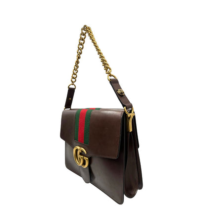 lato  Borsa Gucci in pelle marrone con parti metalliche dorate, impreziosita da striscia Web verde e rossa. Munita di un manico singolo in catena e pelle, indossabile a spalla, di lusso, originale, ottime condizioni. 
