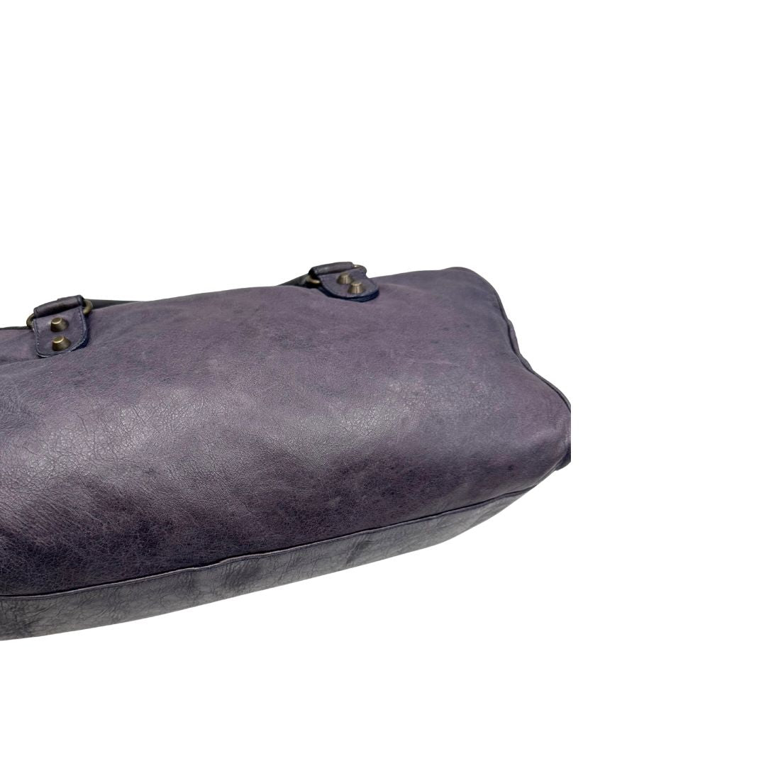 Retro di una Borsa Balenciaga in pelle viola scuro effetto invecchiato con parti metalliche ottone anticato, munita di doppi manici con dettaglio intreccio, e una tracolla amovibile e regolabile con spallaccio. Completa di dustbag. Originale, usata, di lusso, in ottime condizioni.