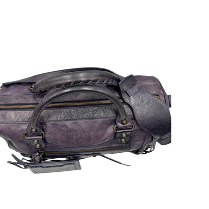 Manici di una Borsa Balenciaga in pelle viola scuro effetto invecchiato con parti metalliche ottone anticato, munita di doppi manici con dettaglio intreccio, e una tracolla amovibile e regolabile con spallaccio. Completa di dustbag. Originale, usata, di lusso, in ottime condizioni.