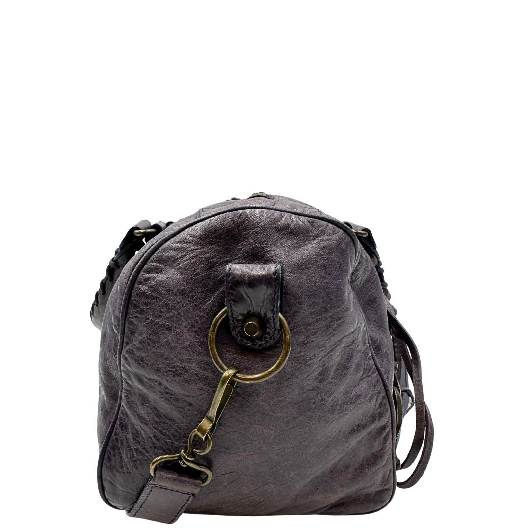 Borsa Balenciaga in pelle viola scuro effetto invecchiato con parti metalliche ottone anticato, munita di doppi manici con dettaglio intreccio, e una tracolla amovibile e regolabile con spallaccio. Completa di dustbag. Originale, usata, di lusso, in ottime condizioni.