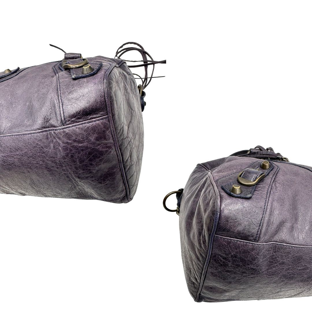 Angoli di una Borsa Balenciaga in pelle viola scuro effetto invecchiato con parti metalliche ottone anticato, munita di doppi manici con dettaglio intreccio, e una tracolla amovibile e regolabile con spallaccio. Completa di dustbag. Originale, usata, di lusso, in ottime condizioni.