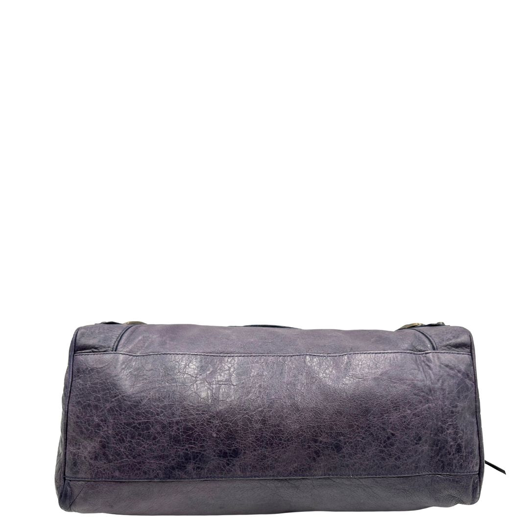 Base di una Borsa Balenciaga in pelle viola scuro effetto invecchiato con parti metalliche ottone anticato, munita di doppi manici con dettaglio intreccio, e una tracolla amovibile e regolabile con spallaccio. Completa di dustbag. Originale, usata, di lusso, in ottime condizioni.