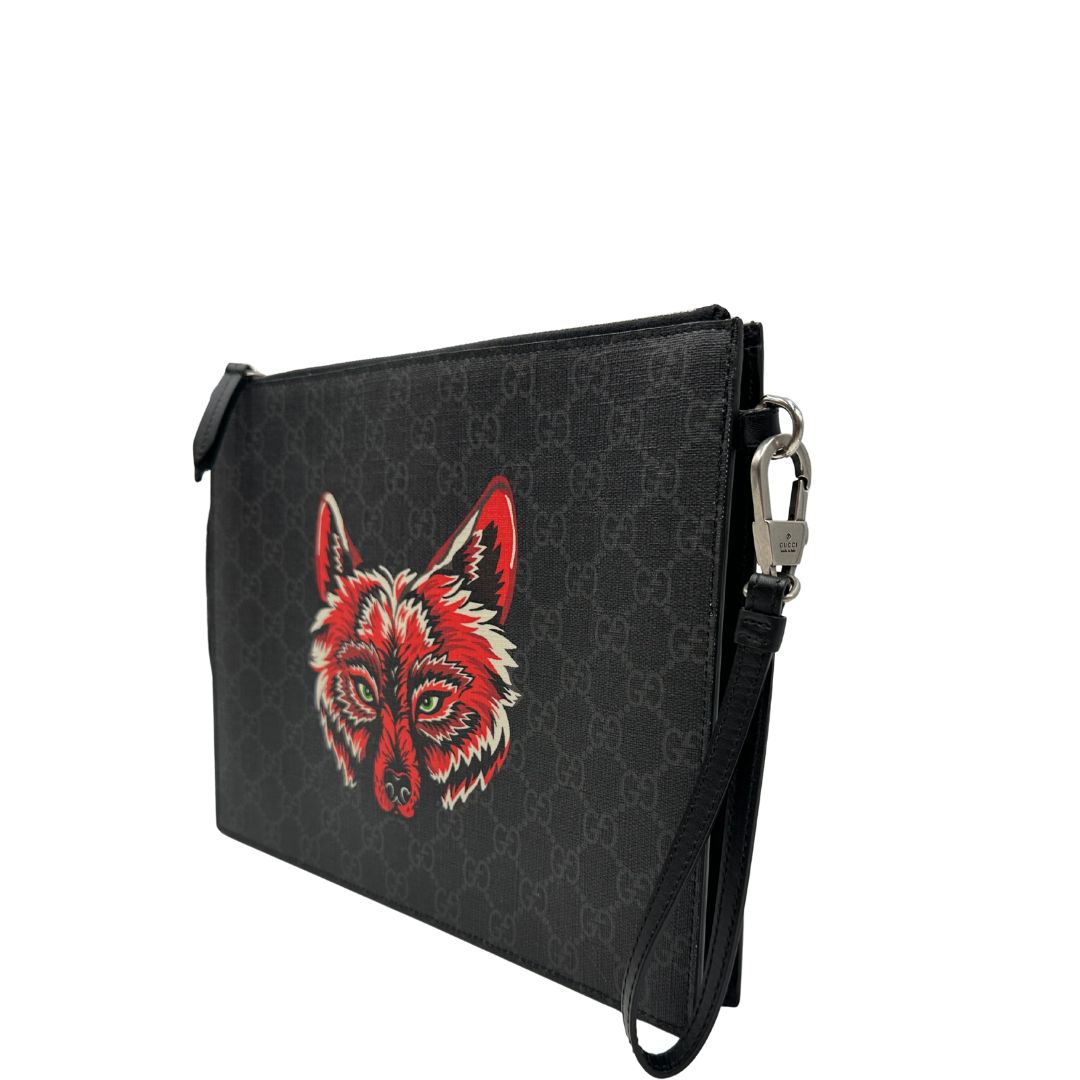 lato  Pochette Gucci in canvas nero con GG grigie antracite e parti metalliche argentate; munita di un polsino e impreziosita da stampa lupo sul front, di lusso,originale, ottime condizioni. 