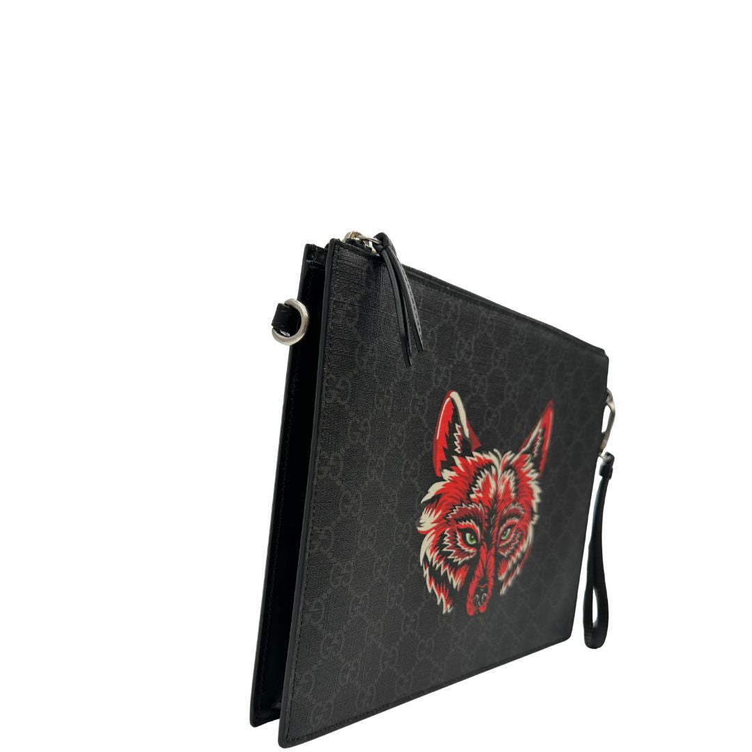 lato  Pochette Gucci in canvas nero con GG grigie antracite e parti metalliche argentate; munita di un polsino e impreziosita da stampa lupo sul front, di lusso,originale, ottime condizioni. 