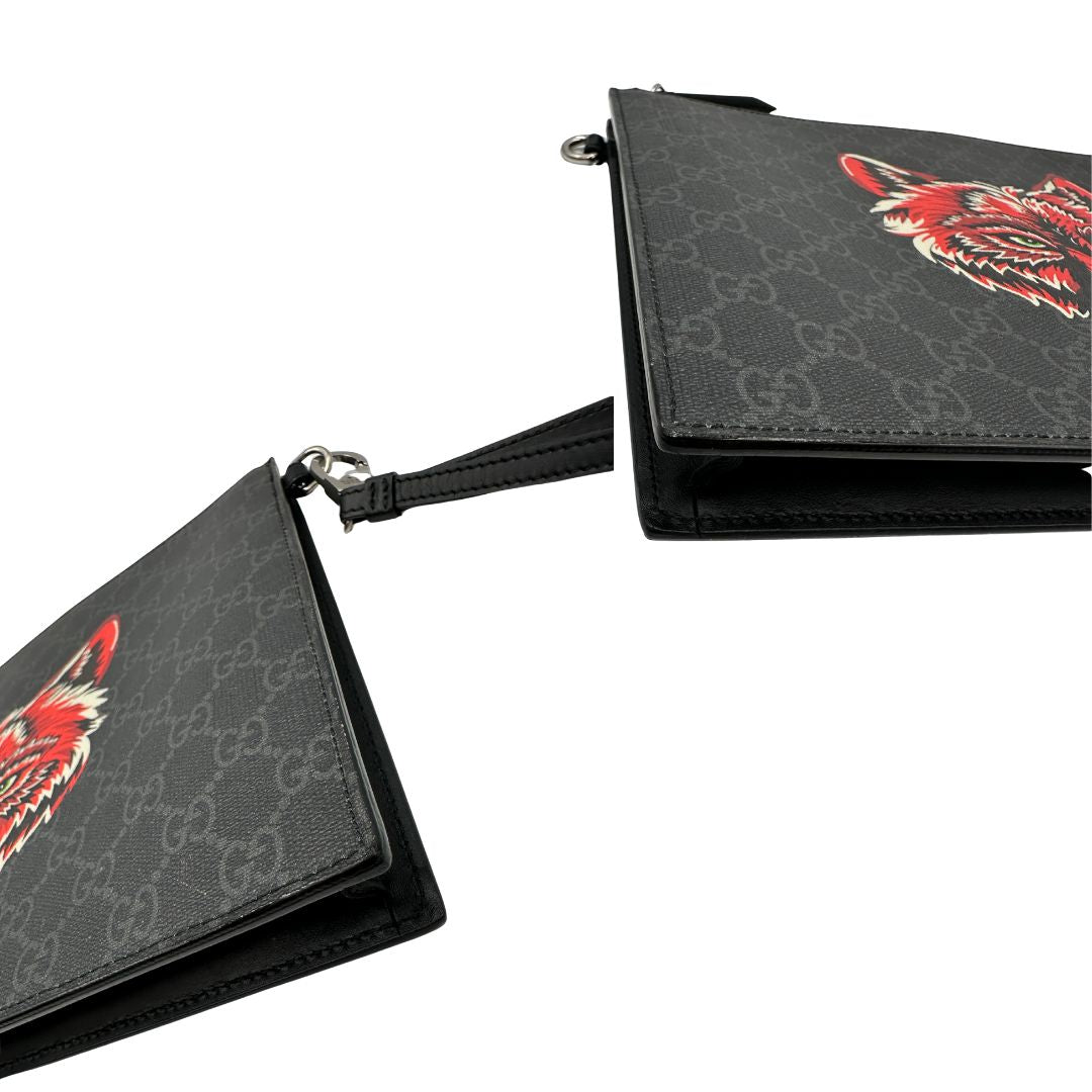 angoli  Pochette Gucci in canvas nero con GG grigie antracite e parti metalliche argentate; munita di un polsino e impreziosita da stampa lupo sul front, di lusso,originale, ottime condizioni. 