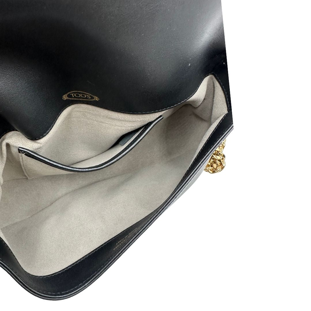 Interno di una Borsa Tod's in pelle nera con parti metalliche dorate; munita di una tracolla in catena e in pelle non amovibile e regolabile. Completa di dustbag. Originale, usata, di lusso, in ottime condizioni.