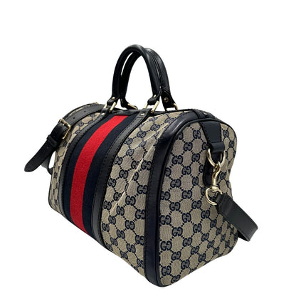 lato  Borsa Gucci in tessuto blu GG con finiture in pelle tono su tono, parti metalliche dorate e striscia Web blu e rossa; munita di doppi manici stondati e una tracolla amovibile e regolabile. Completa di dustbag, di lusso, originale, ottime condizioni, usata. 