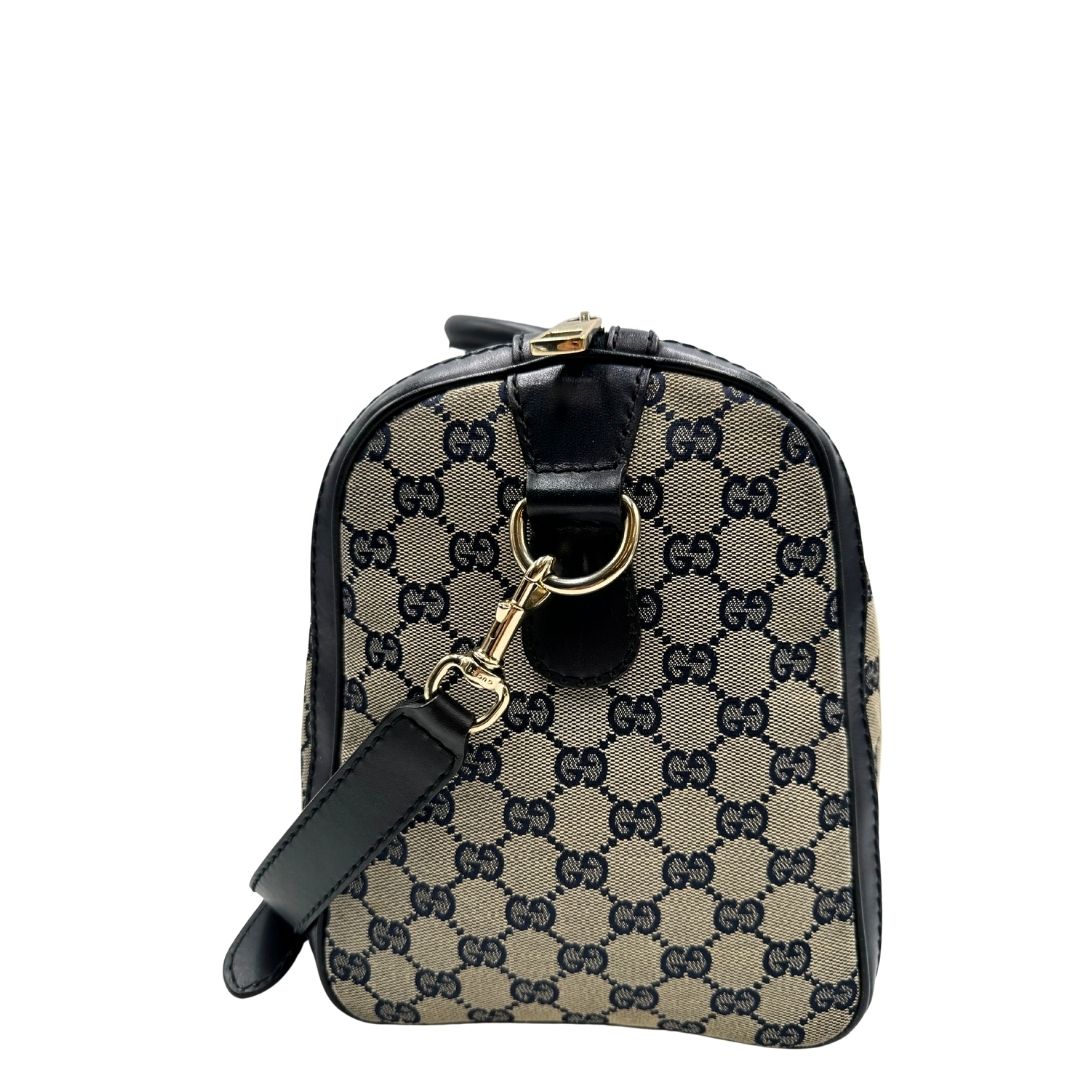 lato  Borsa Gucci in tessuto blu GG con finiture in pelle tono su tono, parti metalliche dorate e striscia Web blu e rossa; munita di doppi manici stondati e una tracolla amovibile e regolabile. Completa di dustbag, di lusso, originale, ottime condizioni, usata. 