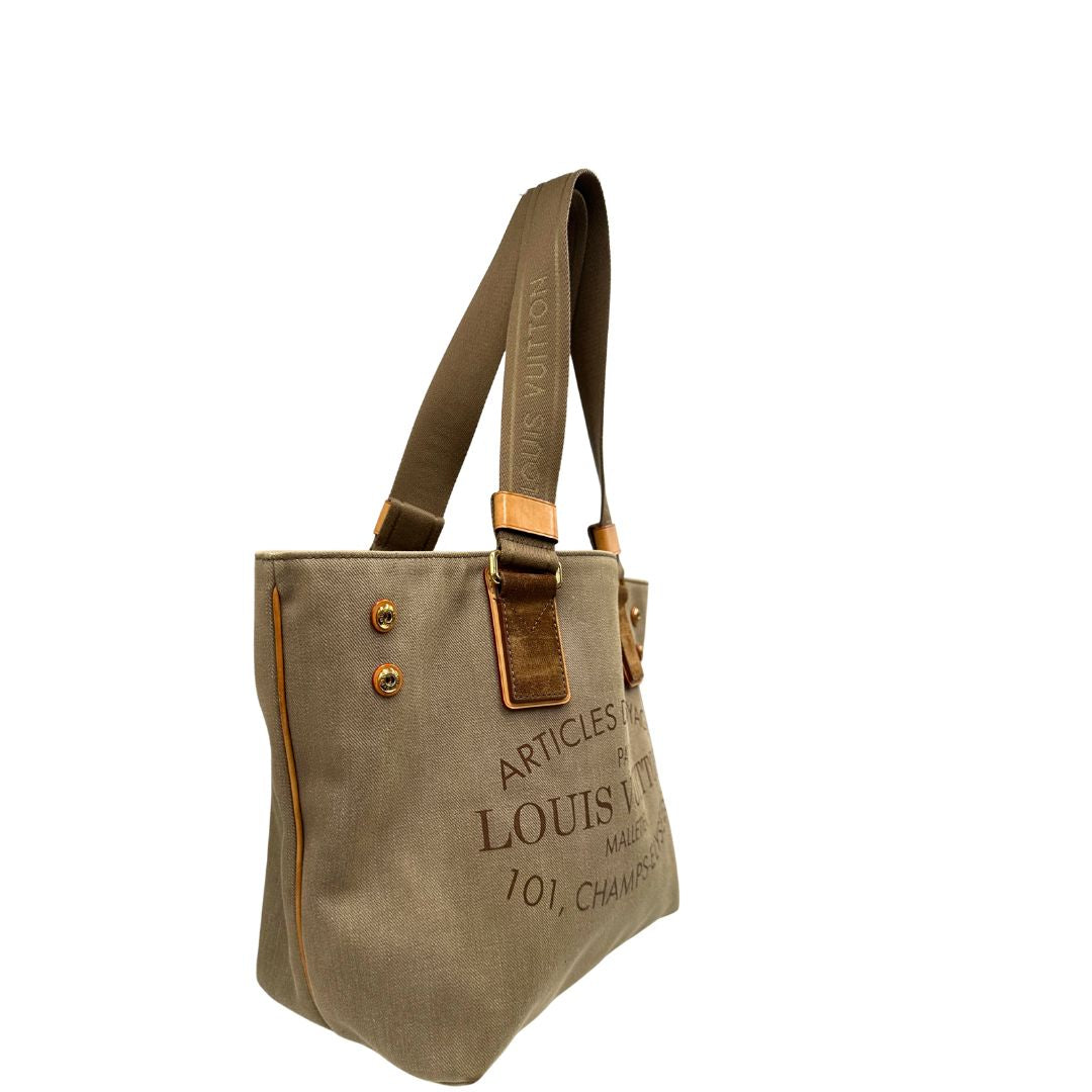 Lato destro di una Borsa Louis Vuitton Limited Edition in tela beige con dettagli in pelle scamosciata marrone e in vacchetta naturale, parti metalliche dorate; munita di doppi manici in tessuto, indossabile a spalla. Completa di dustbag. Originale, usata, di lusso, in ottime condizioni