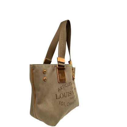 Lato destro di una Borsa Louis Vuitton Limited Edition in tela beige con dettagli in pelle scamosciata marrone e in vacchetta naturale, parti metalliche dorate; munita di doppi manici in tessuto, indossabile a spalla. Completa di dustbag. Originale, usata, di lusso, in ottime condizioni