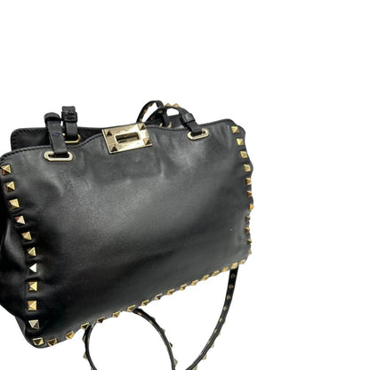 Borsa Valentino Garavani in pelle nera con parti metalliche dorate; impreziosita da borchie piramidali e munita di doppi manici e una tracolla amovibile. Completa di dustbag e cartellino. Originale, usata, di lusso, in ottime condizioni.