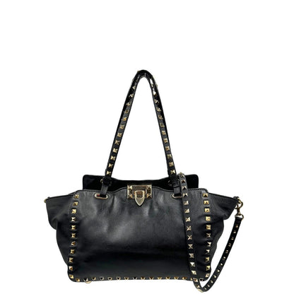 Front di una Borsa Valentino Garavani in pelle nera con parti metalliche dorate; impreziosita da borchie piramidali e munita di doppi manici e una tracolla amovibile. Completa di dustbag e cartellino. Originale, usata, di lusso, in ottime condizioni.