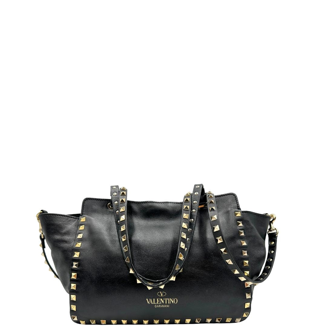 Retro di una Borsa Valentino Garavani in pelle nera con parti metalliche dorate; impreziosita da borchie piramidali e munita di doppi manici e una tracolla amovibile. Completa di dustbag e cartellino. Originale, usata, di lusso, in ottime condizioni.