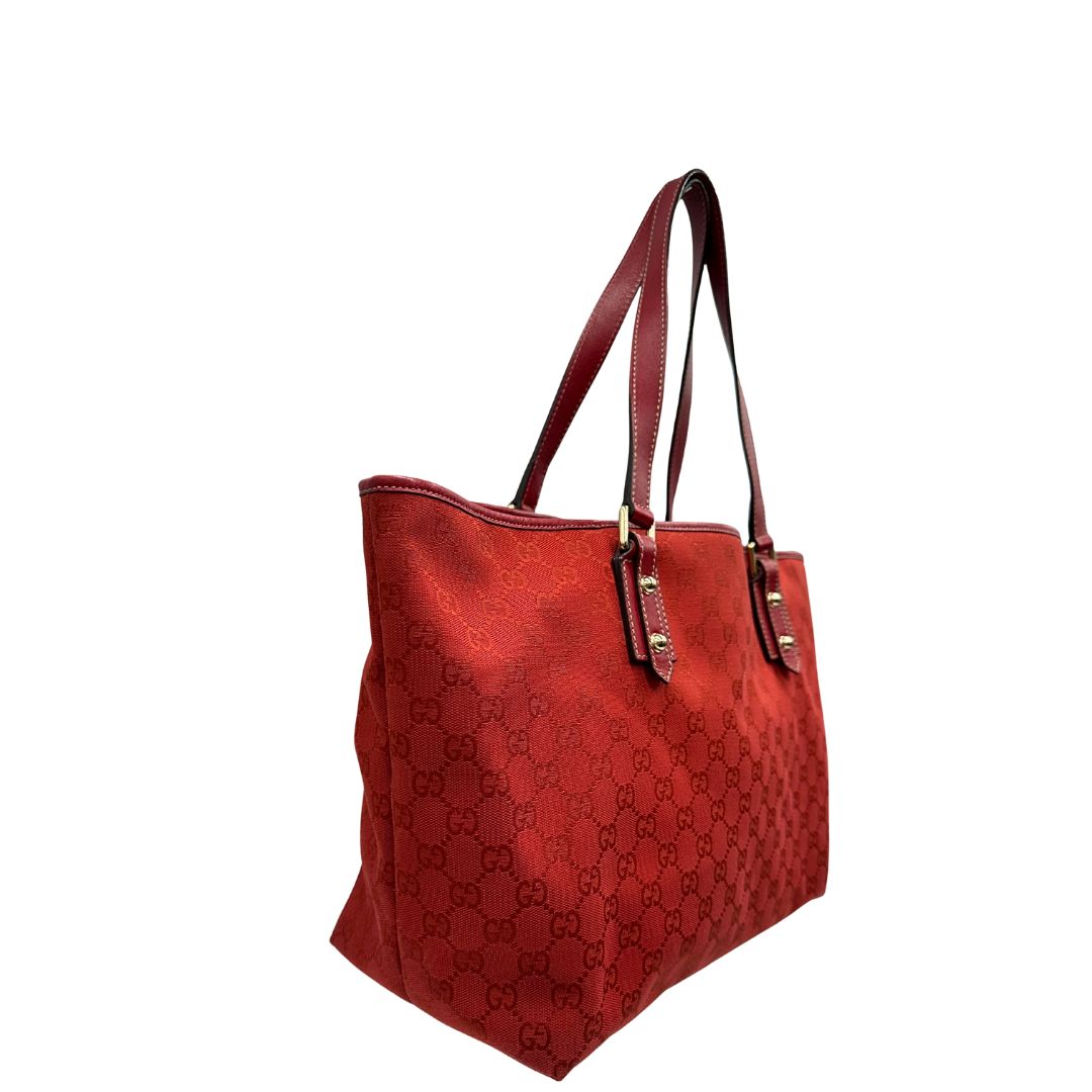 lato  Borsa Gucci in tessuto GG color rosso corallo con finiture in pelle tono su tono e parti metalliche dorate; munita di doppi manici, indossabile a spalla. Completa di dustbag, di lusso, originale, usata. 