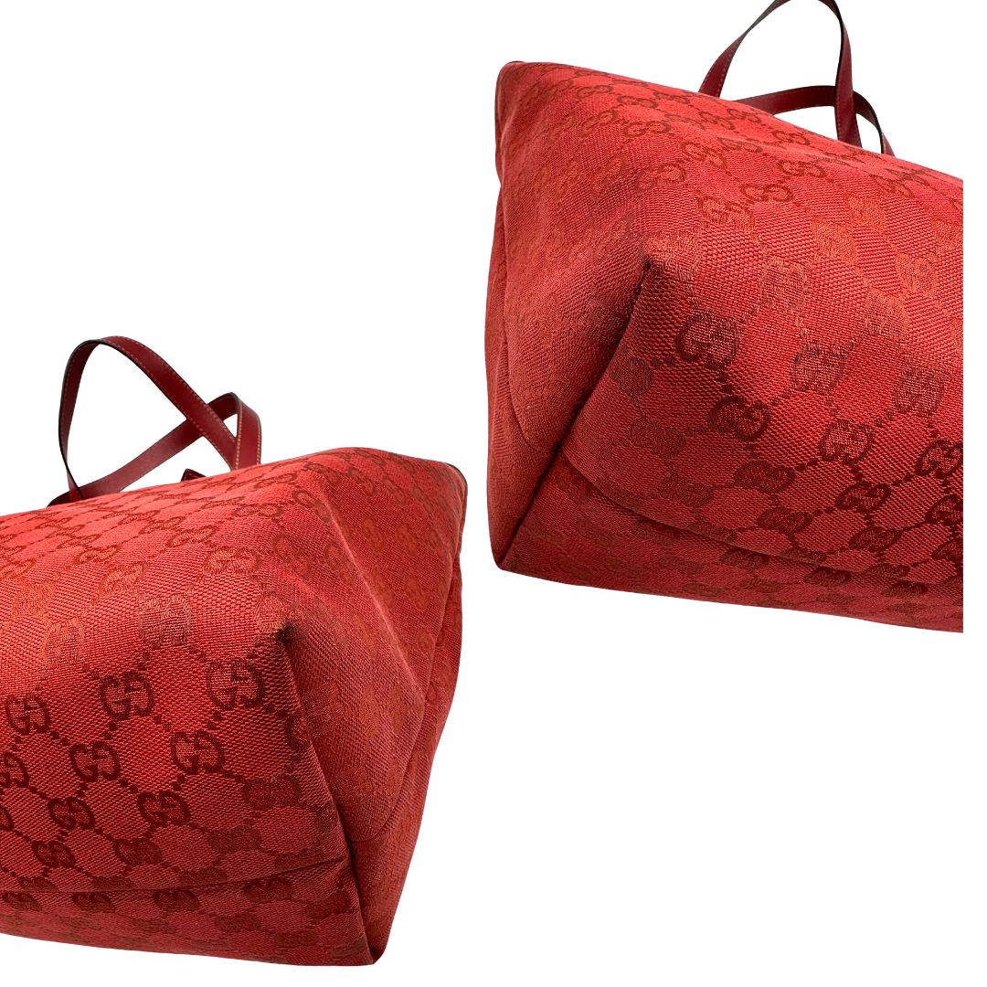 angoli  Borsa Gucci in tessuto GG color rosso corallo con finiture in pelle tono su tono e parti metalliche dorate; munita di doppi manici, indossabile a spalla. Completa di dustbag, di lusso, originale, usata. 