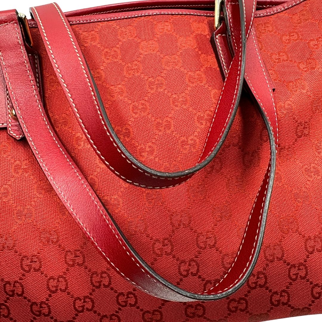 manici  Borsa Gucci in tessuto GG color rosso corallo con finiture in pelle tono su tono e parti metalliche dorate; munita di doppi manici, indossabile a spalla. Completa di dustbag, di lusso, originale, usata. 