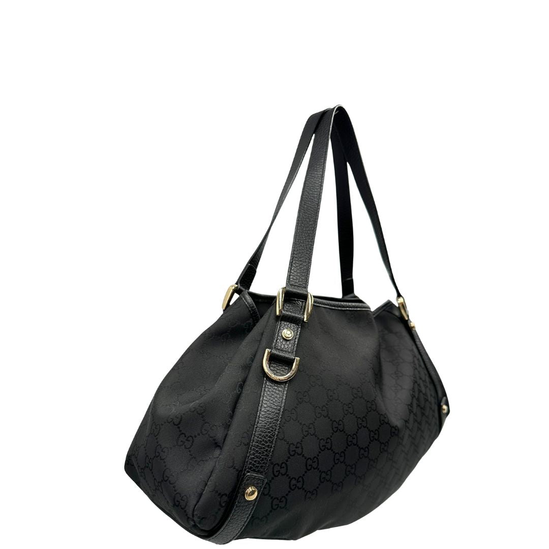 lato  Borsa Gucci in tessuto nero GG con finiture in pelle tono su tono e parti metalliche dorate; munita di doppi manici, indossabile a spalla. Completa di dustbag, di lusso, originale, ottime condizioni, usata. 