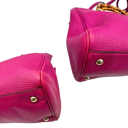angoli Borsa Gucci in pelle martellata fucsia con parti metalliche dorate; munita di doppi manici in bamboo e una tracolla amovibile e regolabile. Completa di dustbag, di lusso, originale, buone condizioni, usata, originale.