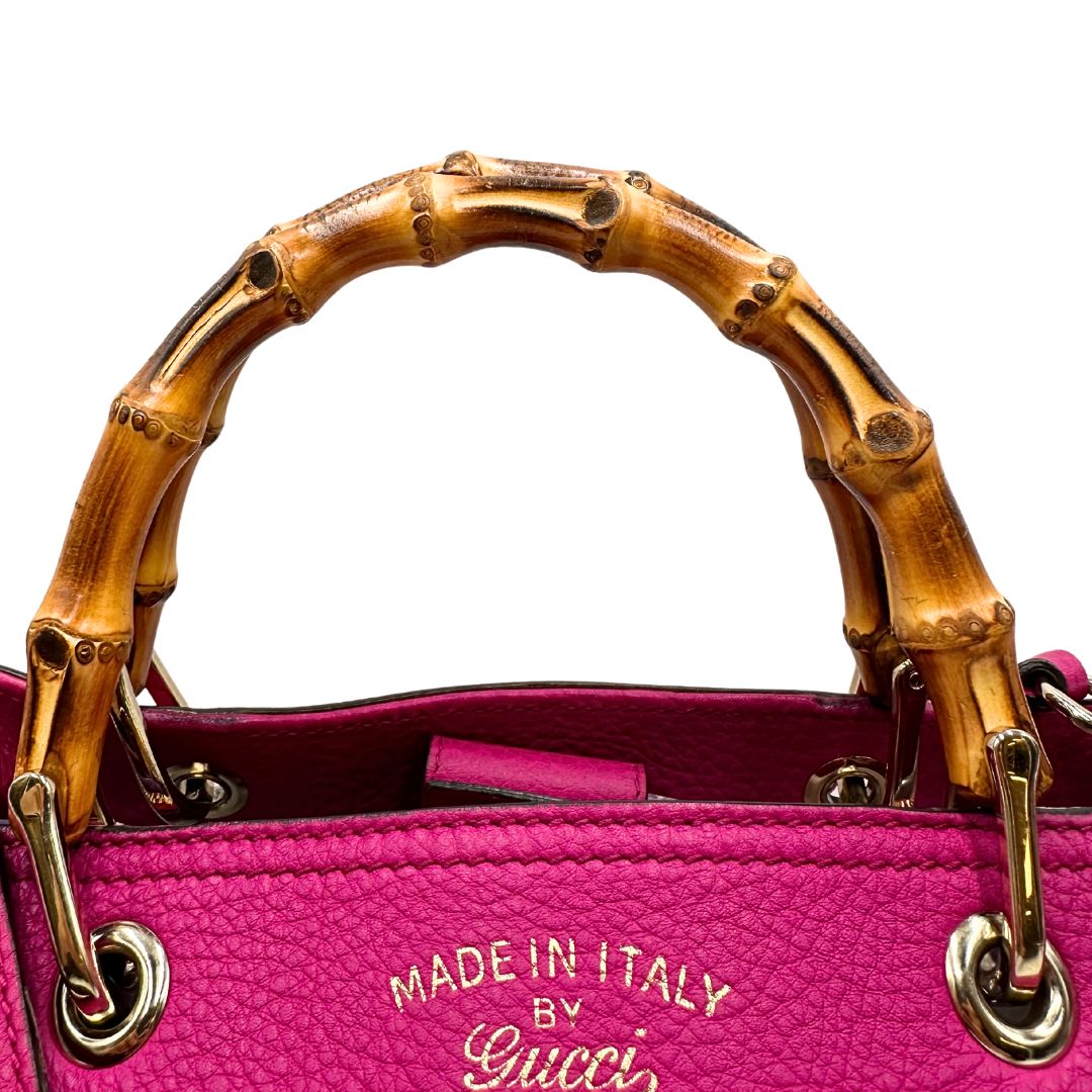 manico Borsa Gucci in pelle martellata fucsia con parti metalliche dorate; munita di doppi manici in bamboo e una tracolla amovibile e regolabile. Completa di dustbag, di lusso, originale, buone condizioni, usata, originale.