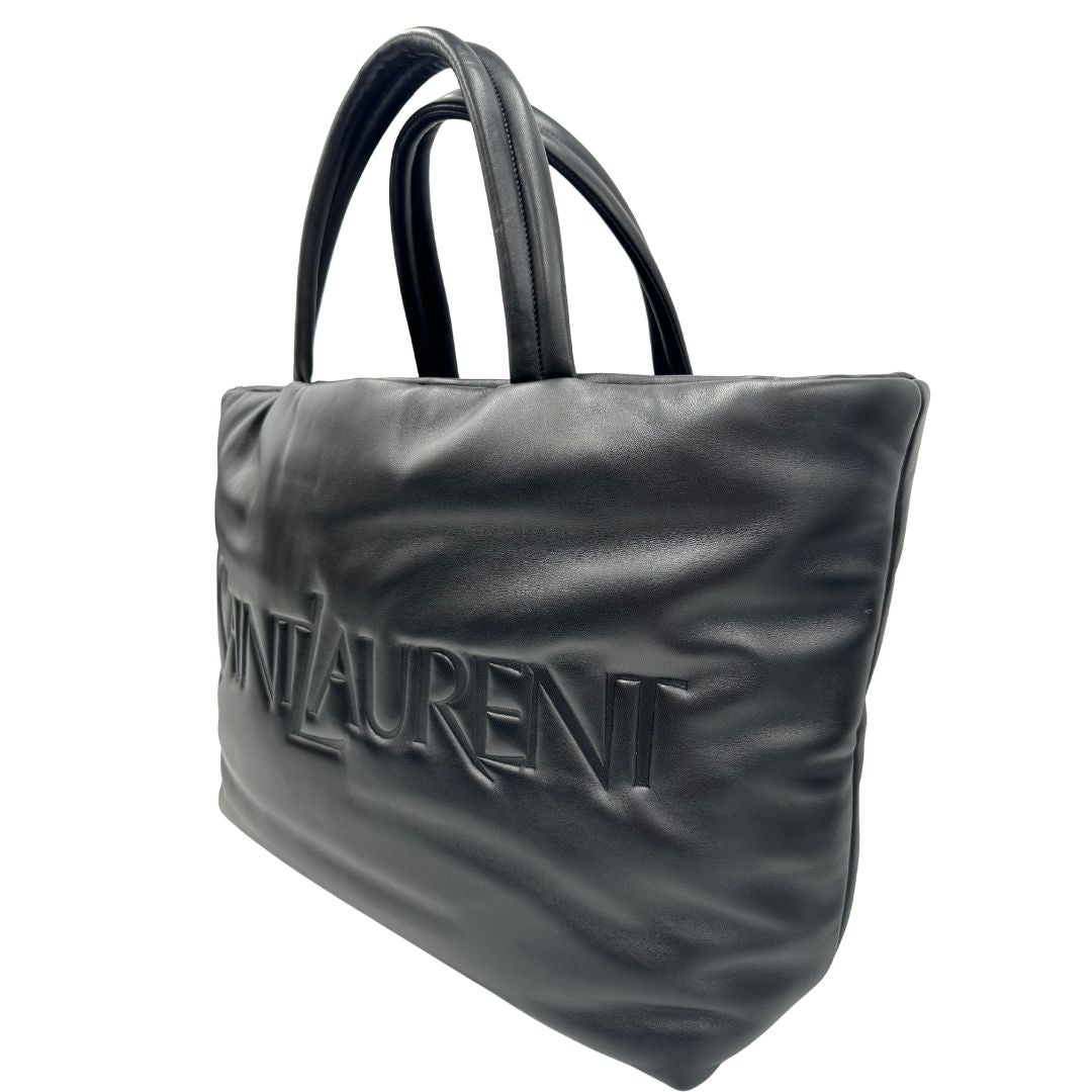 lato  Borsa Saint Laurent in pelle nera con maxi logo sul front; munita di doppi manici, indossabile a spalla. Completa di dustbag, di lusso, originale, eccellenti condizioni.b 