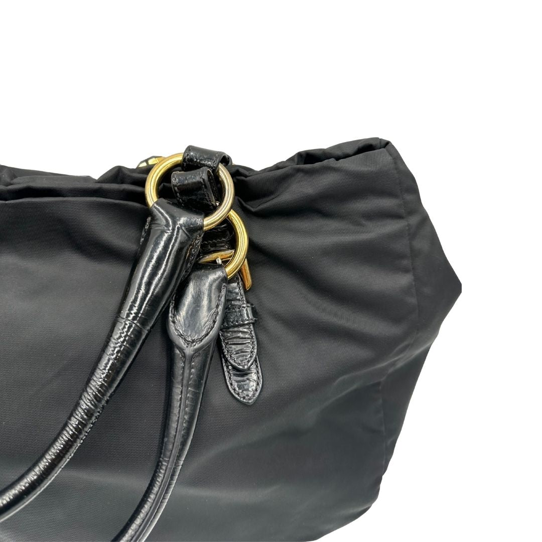  Borsa Prada in nylon nero con parti metalliche dorate e manici in pelle lucida; impreziosita da pietre su tutta la superficie del front; munita di doppi manici stondati, di lusso, originale, ottime condizioni, usata.