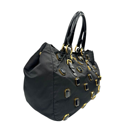 lato  Borsa Prada in nylon nero con parti metalliche dorate e manici in pelle lucida; impreziosita da pietre su tutta la superficie del front; munita di doppi manici stondati, di lusso, originale, ottime condizioni, usata. 