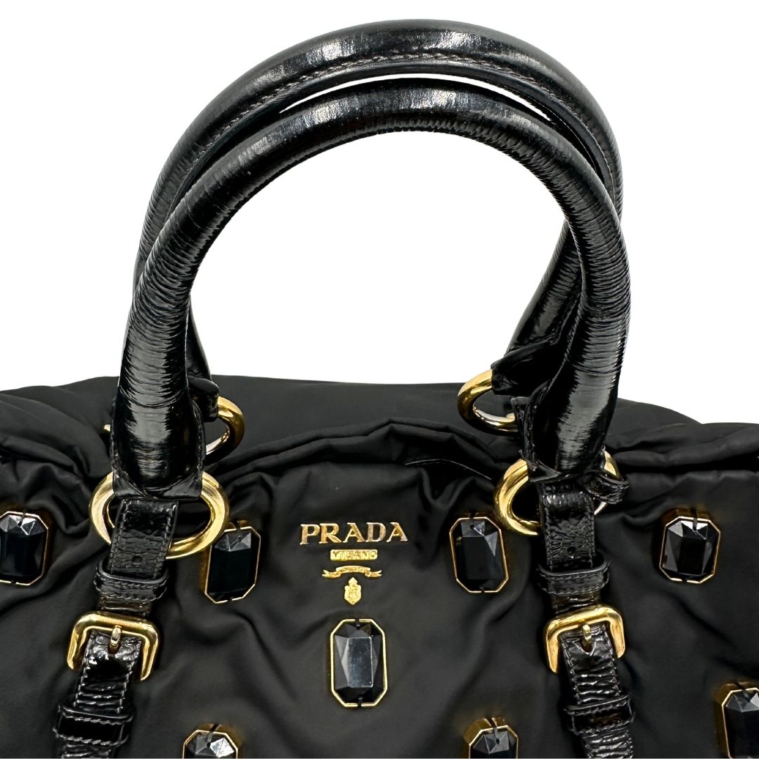 manici  Borsa Prada in nylon nero con parti metalliche dorate e manici in pelle lucida; impreziosita da pietre su tutta la superficie del front; munita di doppi manici stondati, di lusso, originale, ottime condizioni, usata. 