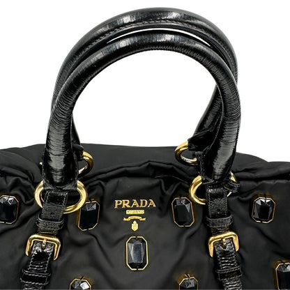 manici  Borsa Prada in nylon nero con parti metalliche dorate e manici in pelle lucida; impreziosita da pietre su tutta la superficie del front; munita di doppi manici stondati, di lusso, originale, ottime condizioni, usata. 