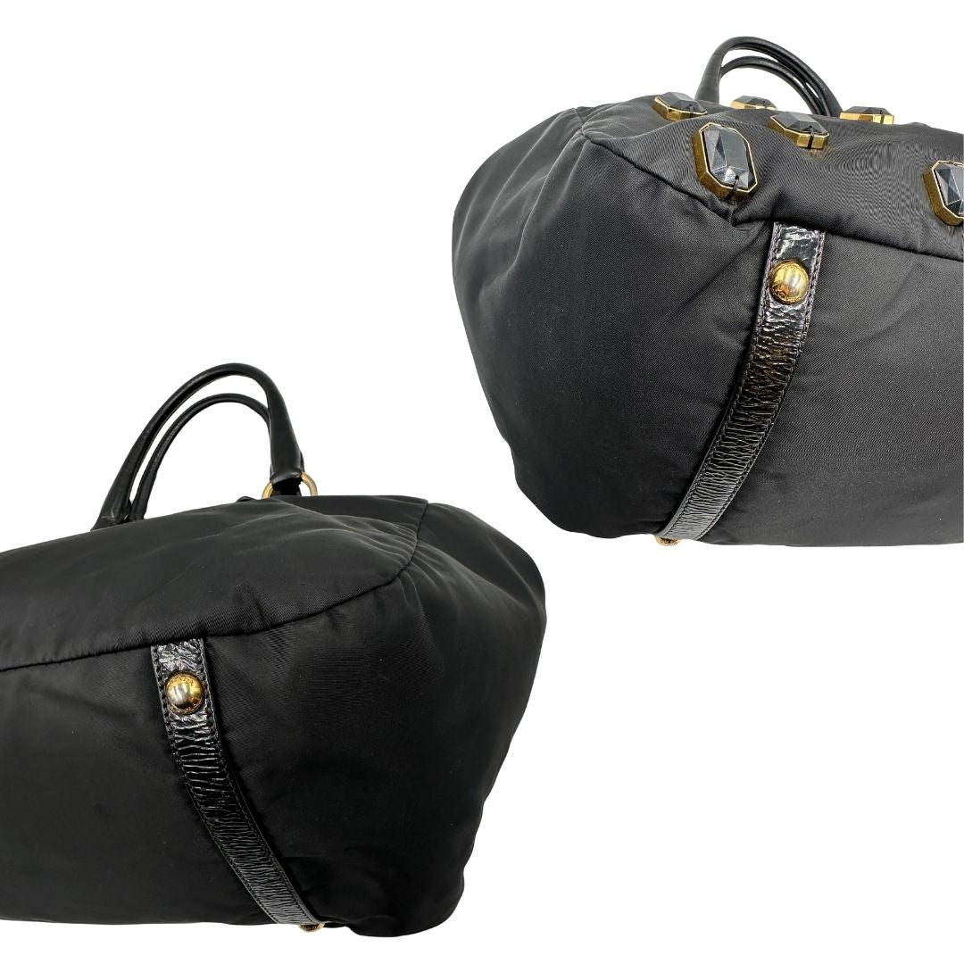 angoli  Borsa Prada in nylon nero con parti metalliche dorate e manici in pelle lucida; impreziosita da pietre su tutta la superficie del front; munita di doppi manici stondati, di lusso, originale, ottime condizioni, usata. 