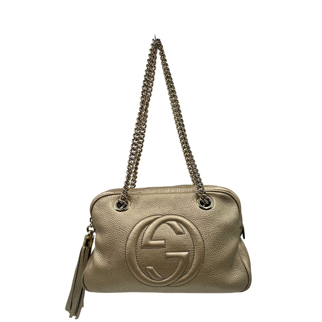 front Borsa Gucci in pelle dorata con parti metalliche tono su tono; munita di doppi manici in catena e impreziosita da nappa decorativa. Completa di dustbag, di lusso, originale, ottime condizioni, usata. 