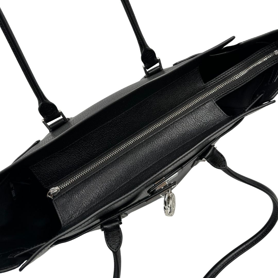 Chiusura di una borsa Michael Kors in pelle nera con parti metalliche argentate; munita di doppi manici. Completa di dustbag. Indossabile a spalla.