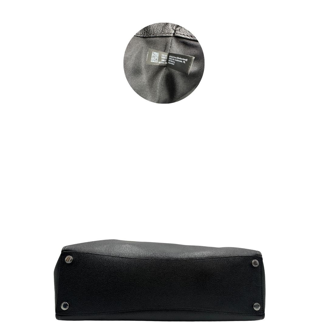 Base e codice di una borsa Michael Kors in pelle nera con parti metalliche argentate; munita di doppi manici. Completa di dustbag. Indossabile a spalla.